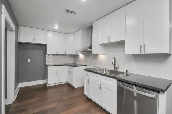 a kitchen with sink cabinets and wooden floor