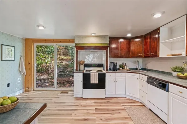 a kitchen with stainless steel appliances granite countertop a stove a sink and a microwave