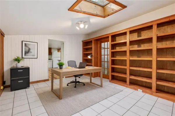 a view of an empty room with cabinet and a window