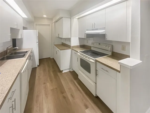 a kitchen with a stove sink and a refrigerator