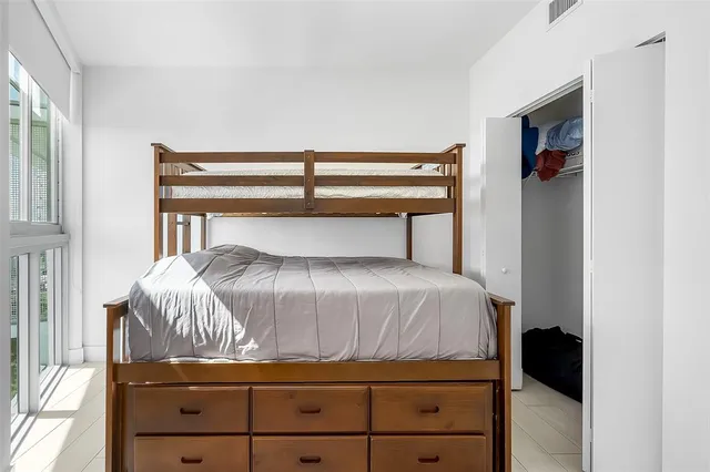 a bed sitting in a bedroom next to a window
