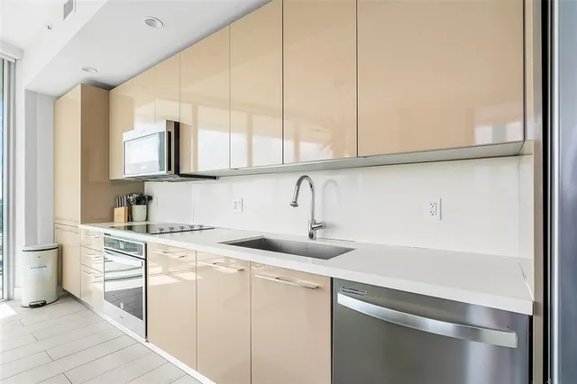 a kitchen with stainless steel appliances granite countertop a sink and a white cabinets