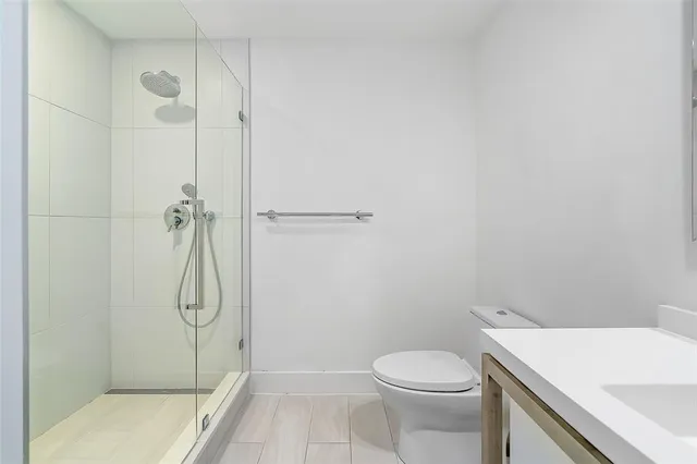 a bathroom with a shower a toilet and a sink