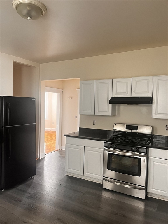 a kitchen with granite countertop a refrigerator and a stove