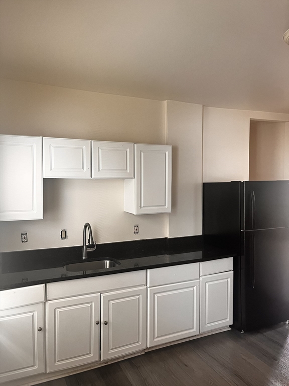 27 Irma Street, Unit 1 Boston, MA 02124 - Photo 2 of 8 a kitchen with granite countertop white cabinets and black appliances