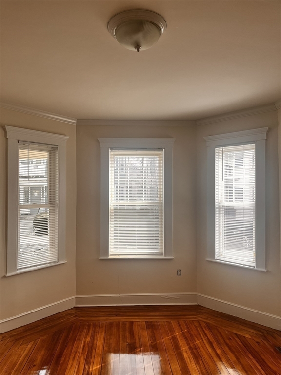 27 Irma Street, Unit 1 Boston, MA 02124 - Photo 3 of 8 a view of an empty room with wooden floor and a window
