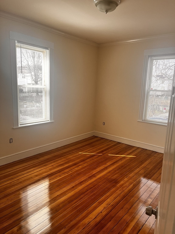 27 Irma Street, Unit 1 Boston, MA 02124 - Photo 7 of 8 an empty room with wooden floor and windows