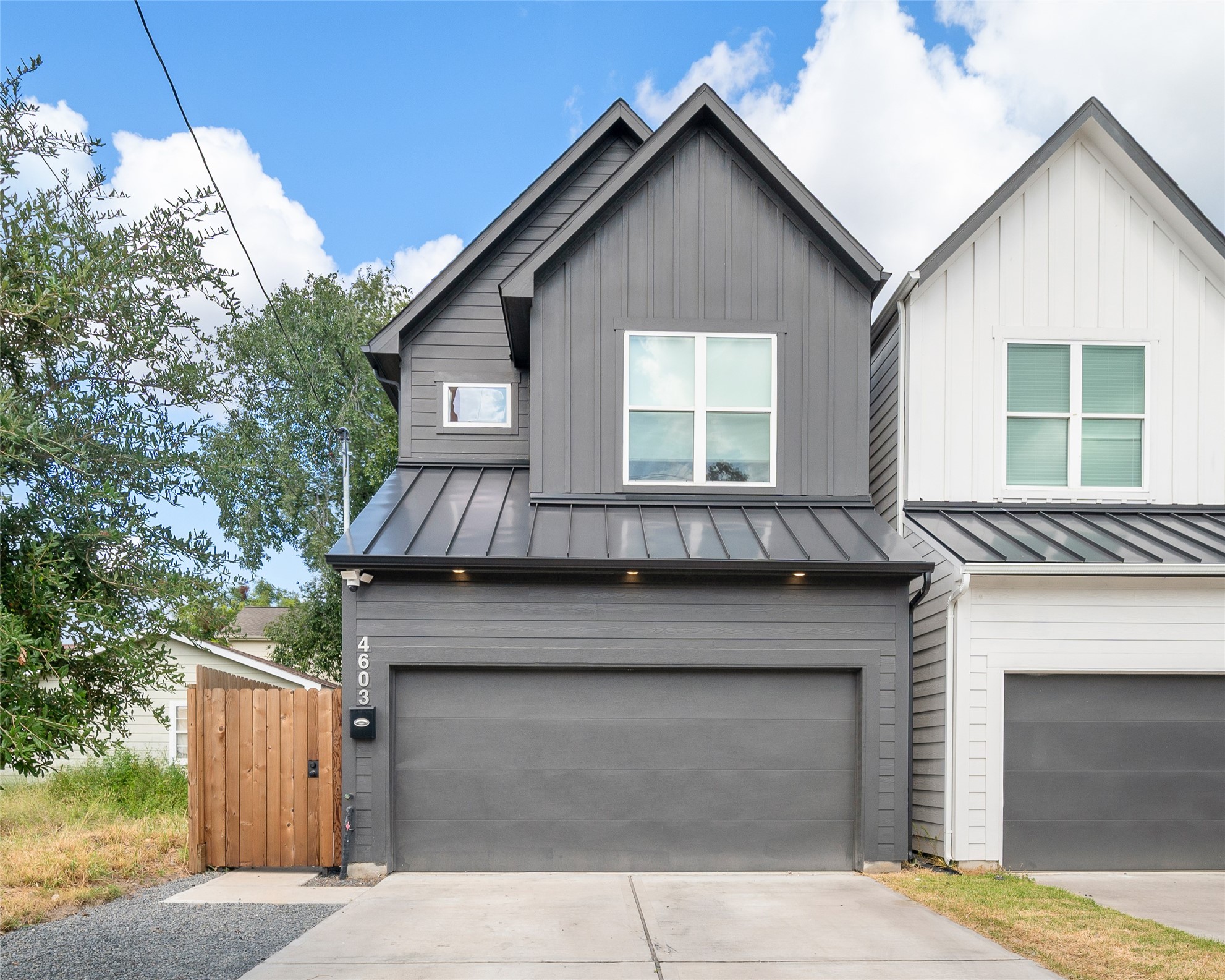 4603 Terry Street Houston, TX 77009 - Photo 1 of 41 Modern two-story home with sleek gray siding, and an attached garage. The driveway offers ample parking, and a wooden gate leads to a private entrance.