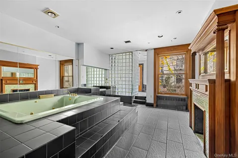 a living room with stainless steel appliances furniture a rug and a large window