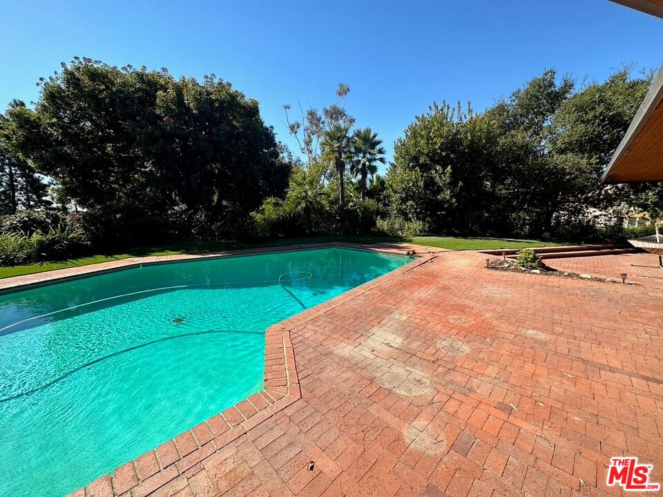 590 North Tigertail Road Los Angeles, CA 90049 - Photo 14 of 69 a view of a tennis ground with large trees in the background