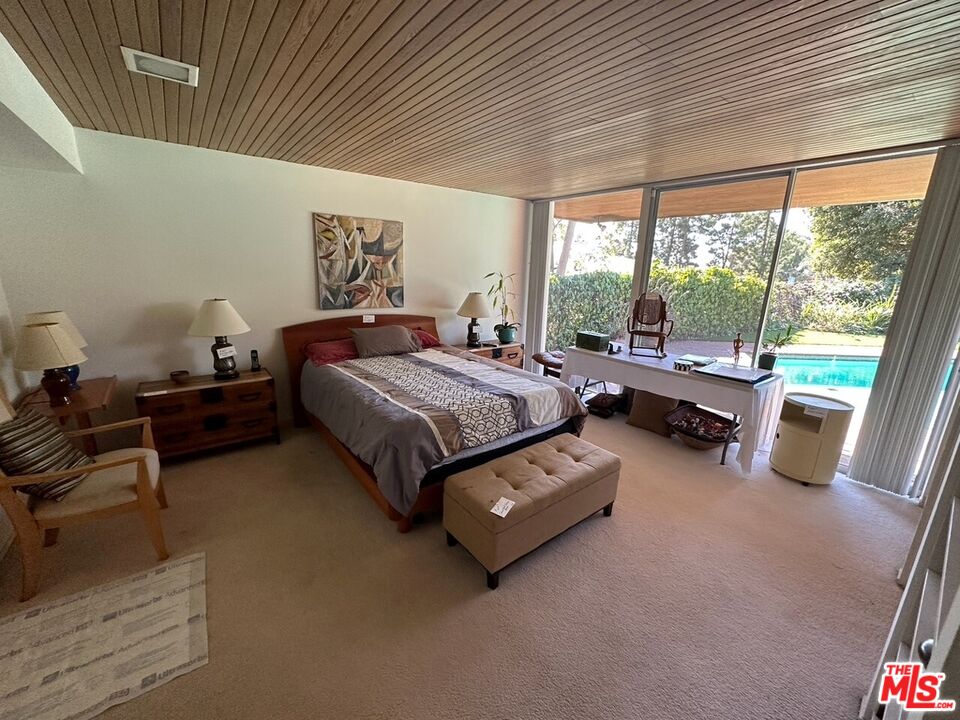 590 North Tigertail Road Los Angeles, CA 90049 - Photo 18 of 69 a bedroom with furniture and a large window