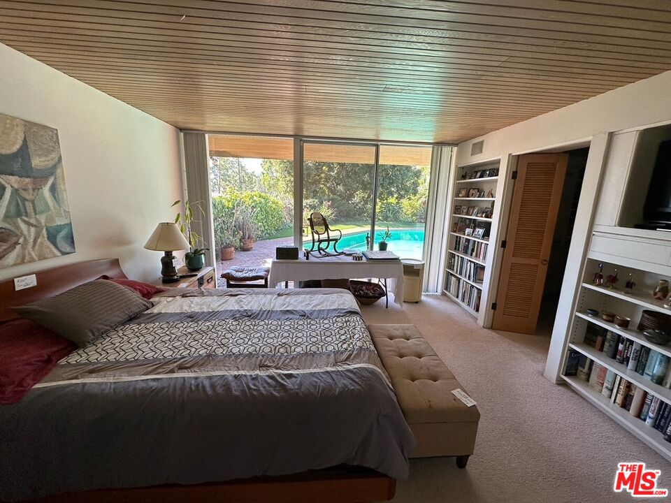 590 North Tigertail Road Los Angeles, CA 90049 - Photo 20 of 69 a bed sitting in a bedroom next to a window