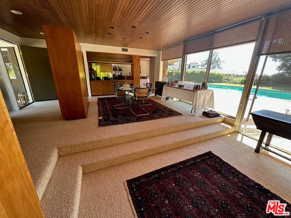 590 North Tigertail Road Los Angeles, CA 90049 - Photo 10 of 69 a bed room with a bed and large windows