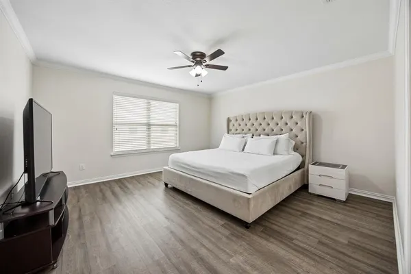 a bedroom with a bed and a flat tv screen on the dresser