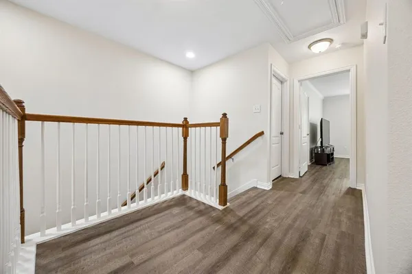 a view of a hallway with wooden floor and stairs
