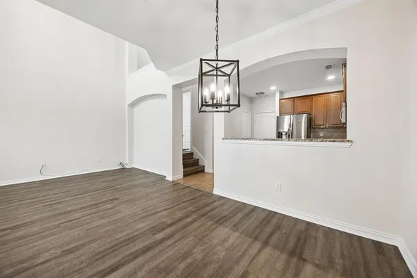 a view of a kitchen with wooden floor and refrigerator