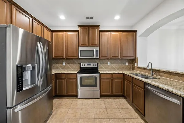 a kitchen with stainless steel appliances granite countertop a refrigerator sink and cabinets