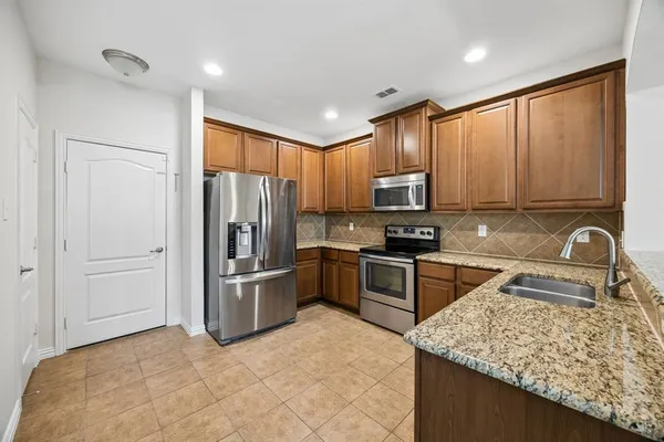 a kitchen with stainless steel appliances granite countertop a refrigerator stove and oven