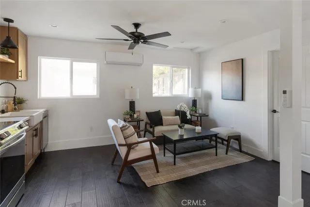 a living room with furniture a flat screen tv and kitchen view