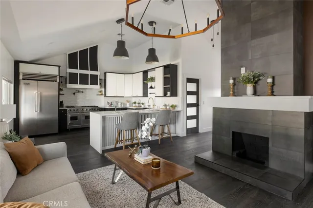 a living room with furniture a fireplace and kitchen view