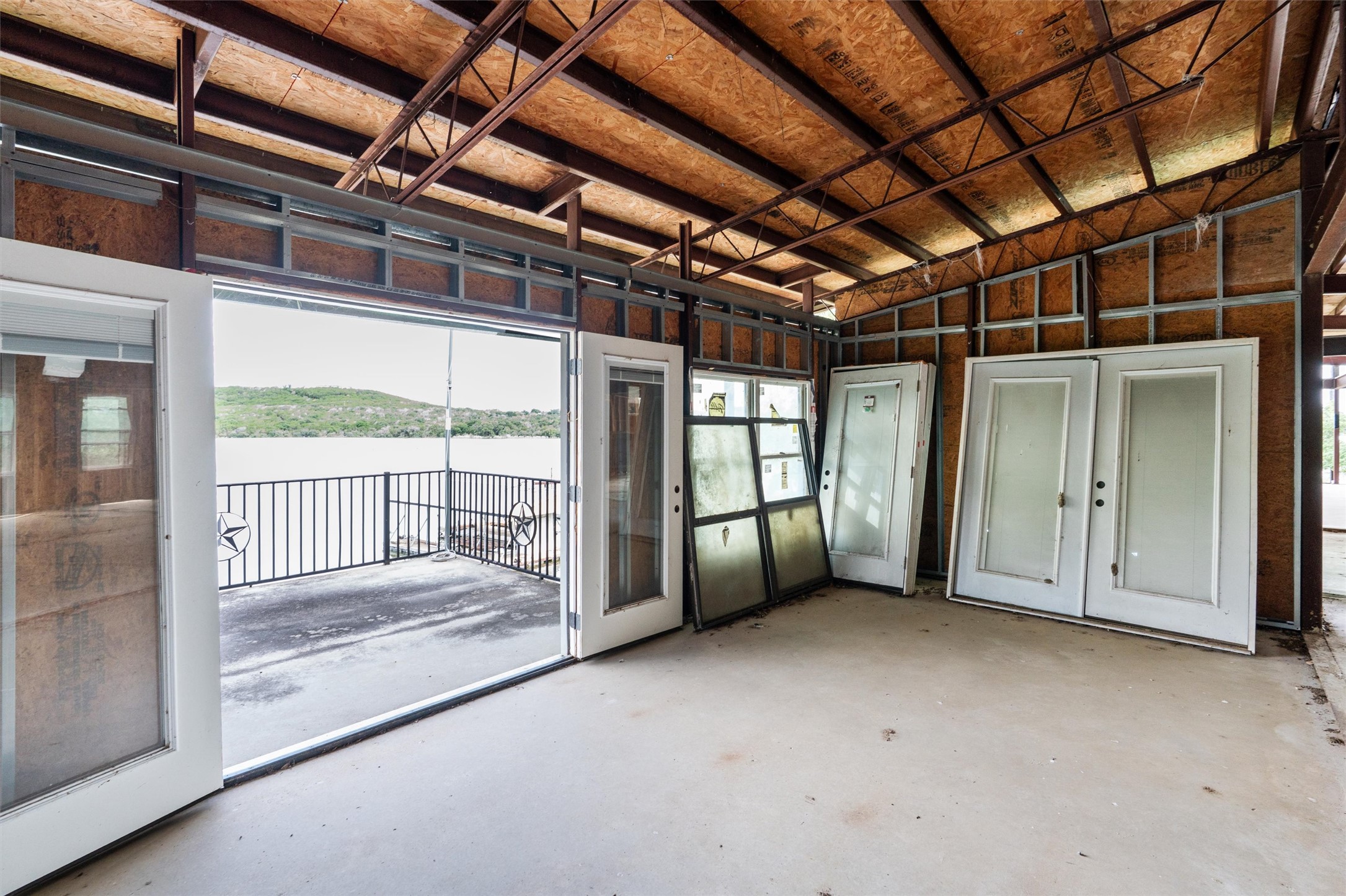 325 Eagle Rest Burnet, TX 78611 - Photo 33 of 40 A spacious, open interior ready for customization, featuring a private patio overlooking tranquil waters and distant hills.
