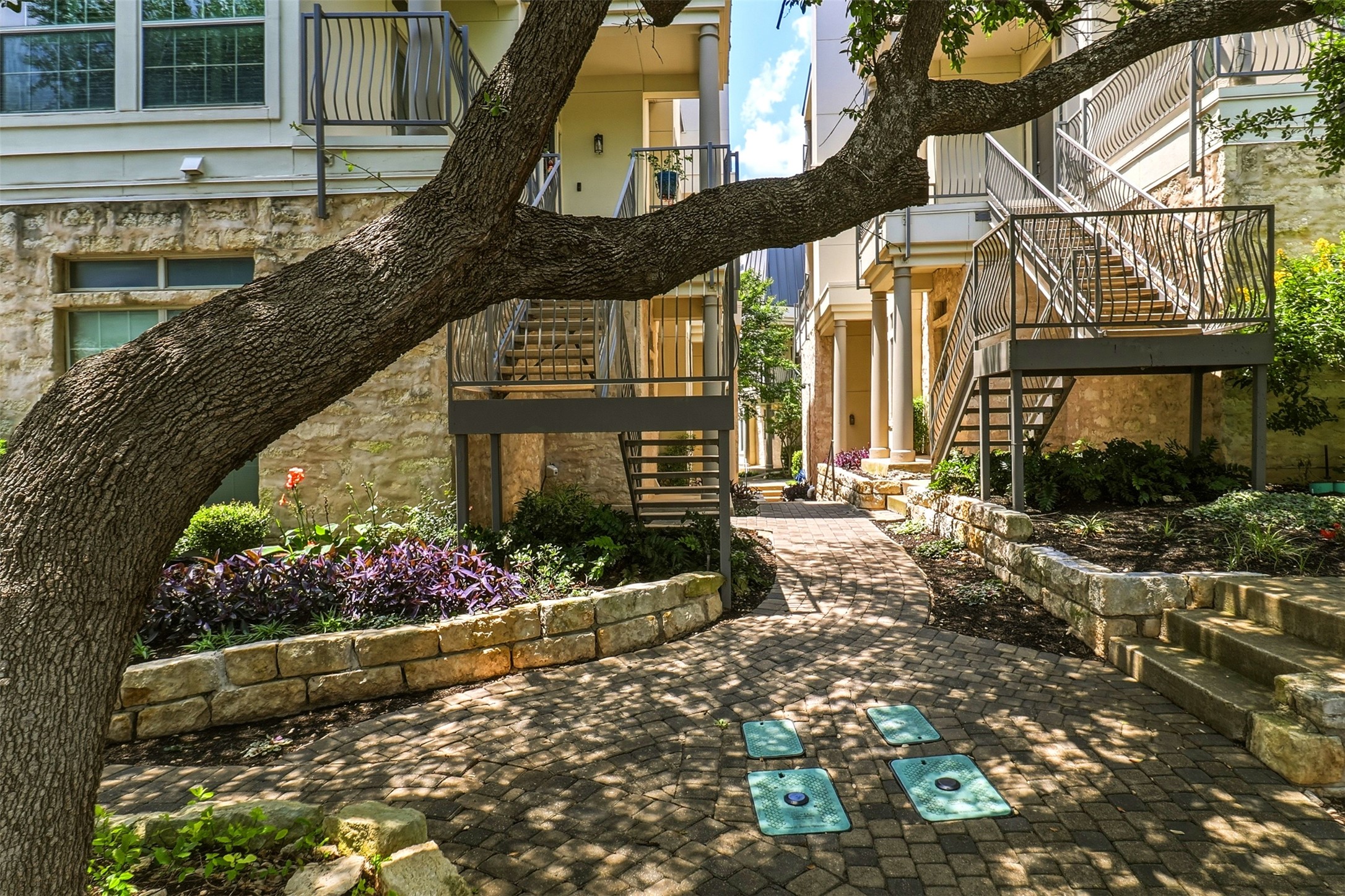 2918 Ranch Road 620, Unit 265 Austin, TX 78734 - Photo 23 of 40 A quaint paved walkway winds through meticulously landscaped gardens, offering a charming communal passage.