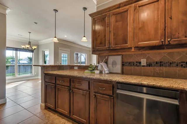 a kitchen with granite countertop a sink a stove and cabinets