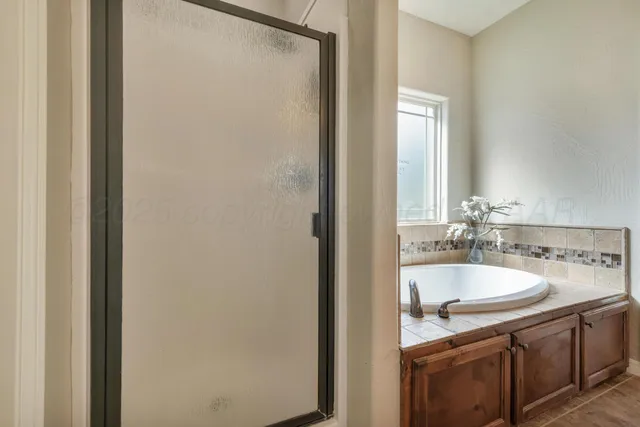 a bathroom with a granite countertop sink a large mirror and a bathtub