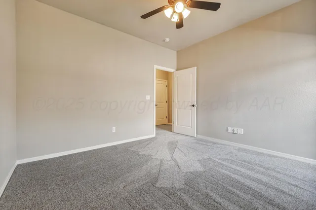 an empty room with chandelier fan