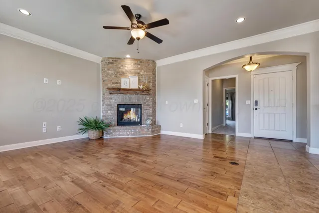 a view of an empty room and chandelier fan