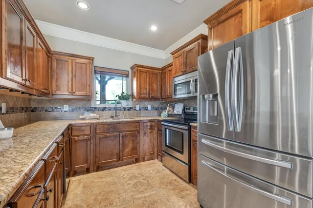 a kitchen with stainless steel appliances granite countertop a refrigerator sink and stove