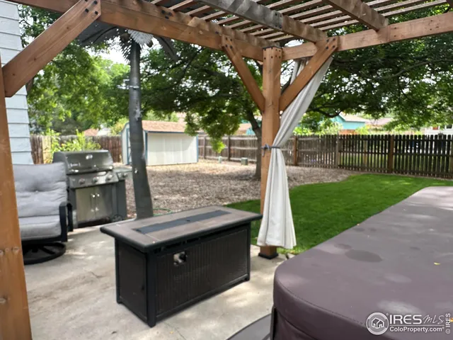 a view of a backyard with couches plants and large tree