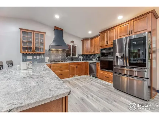 a kitchen with stainless steel appliances granite countertop a sink a stove and a refrigerator
