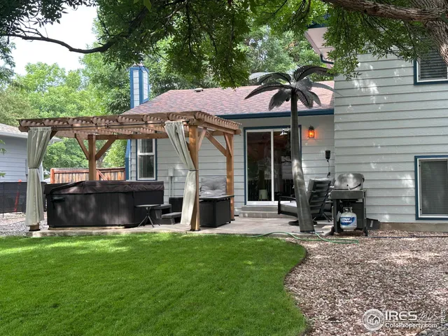 a view of a chair and table in backyard of the house