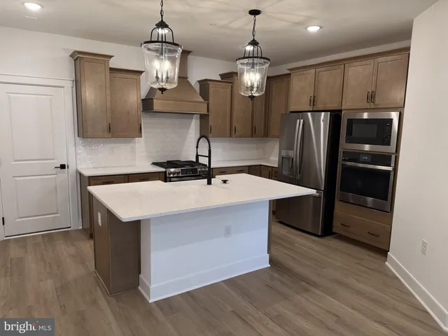 a kitchen with kitchen island granite countertop a sink and refrigerator