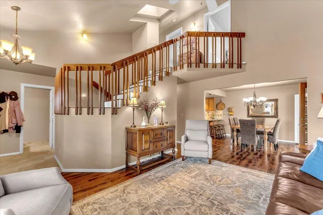 a living room with couches and dining table with wooden floor
