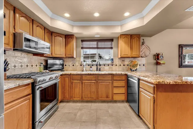 a kitchen with stainless steel appliances granite countertop a stove sink and cabinets