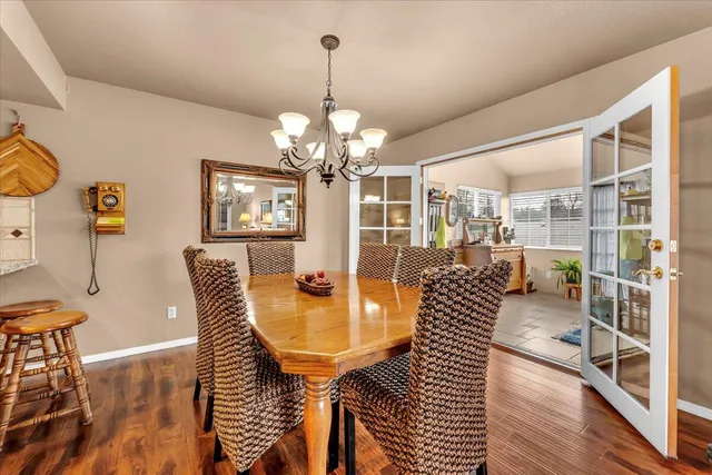 a dining room with furniture a chandelier and wooden floor