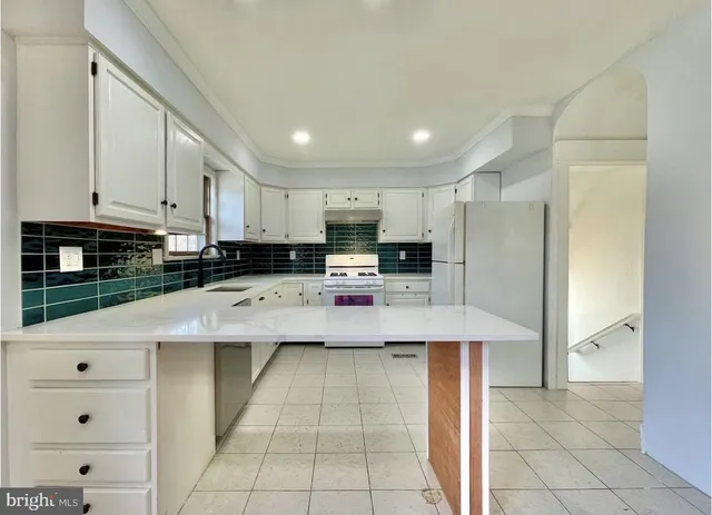 a kitchen with stainless steel appliances kitchen island granite countertop a refrigerator and a stove