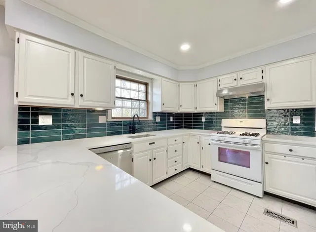 a kitchen with granite countertop white cabinets and stainless steel appliances