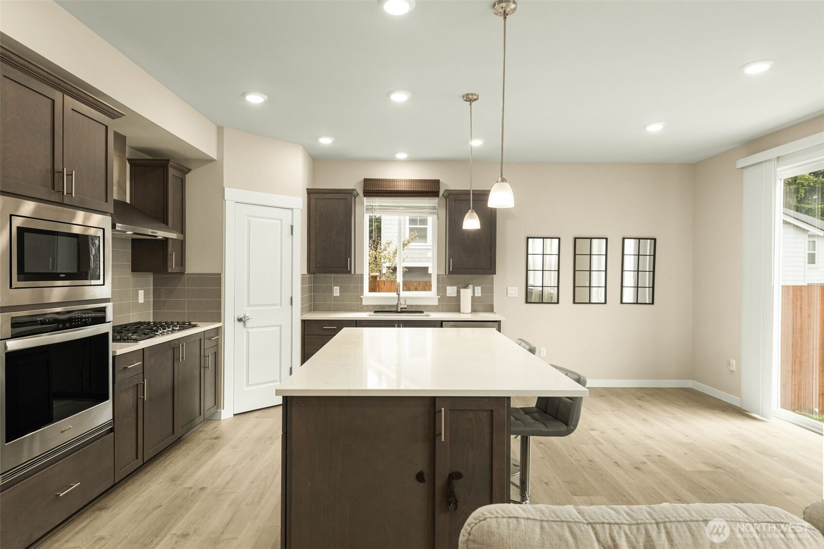 19410 28th Drive Southeast Bothell, WA 98012 - Photo 12 of 37 a kitchen with stainless steel appliances kitchen island granite countertop a refrigerator a stove and a sink with wooden floor