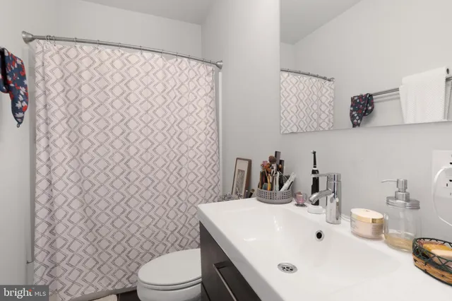 a bathroom with a sink a toilet and a mirror