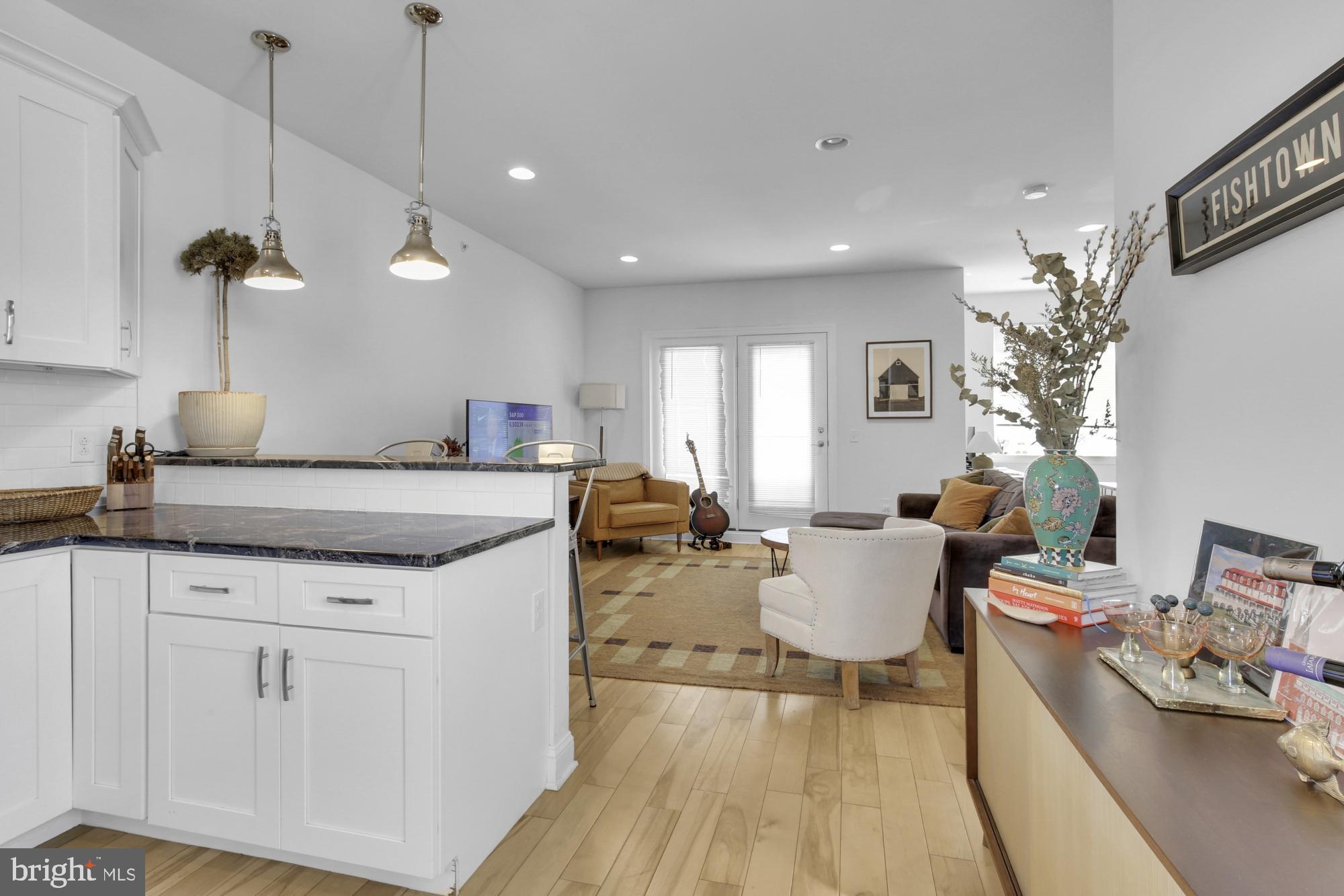 2302 Collins Street Philadelphia, PA 19125 - Photo 29 of 37 a living room with stainless steel appliances granite countertop couches a fireplace a flat screen tv and a dining table with wooden floor