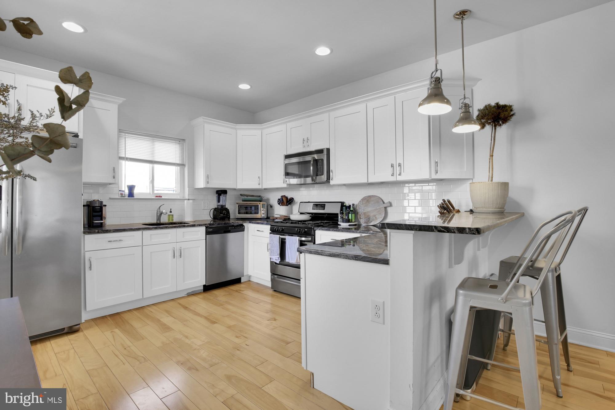 2302 Collins Street Philadelphia, PA 19125 - Photo 31 of 37 a kitchen with stainless steel appliances granite countertop a sink a stove a refrigerator cabinets and a window