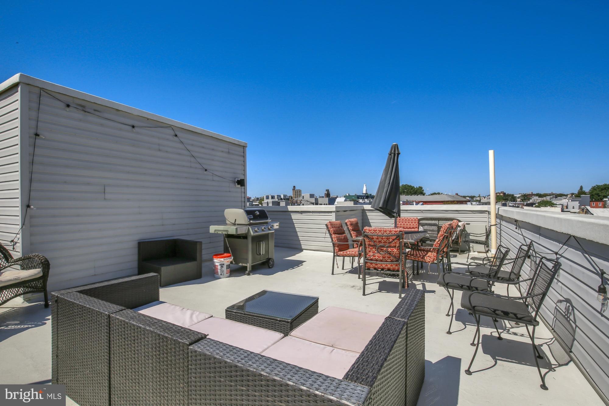 2302 Collins Street Philadelphia, PA 19125 - Photo 35 of 37 a roof deck with couches table and chairs with potted plants