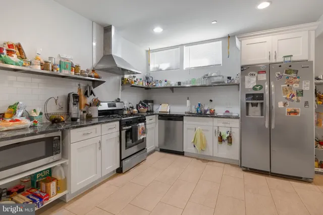 a kitchen with stainless steel appliances granite countertop a refrigerator and a stove