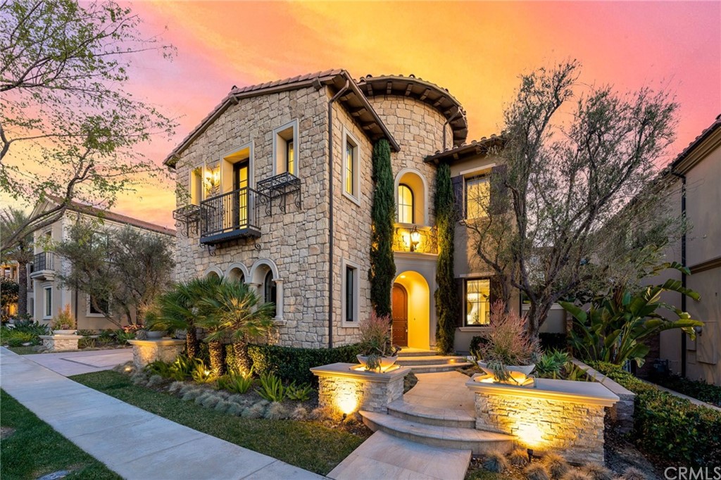 a view of a building with brick walls plants and large tree