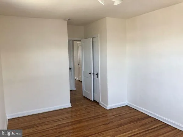 a view of an empty room with wooden floor