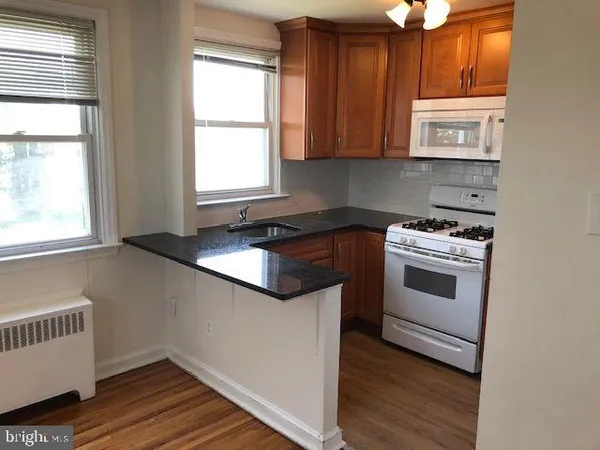 a kitchen with granite countertop white cabinets and white appliances