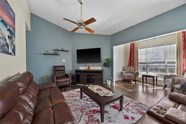 a living room with furniture a flat screen tv and a large window